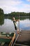 Child Playing on Dock by Fishing Row Boat on Small Lake in Northern Woods