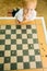 Child playing draughts or checkers board game outdoor