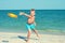 A child is playing with a frisbee on the beach.