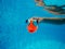 Child playing with generic rubber fish toy in swimming pool