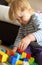 Child playing Lego bricks on floor