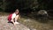 Child Playing at Mountain River at Camping, Tourist Girl Throwing Stones in Stream Water, Kid Outdoor in Trip, Children in Nature