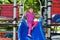 A child is playing on an outdoor playground. An active, cheerful girl rides down a slide.