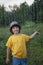 Child playing outdoor on rainy day. Happy boy in summer rain