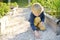 Child playing with pebbles and explores them. Little boy study of various natural materials. Kids explore nature. Alternative