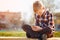 Child playing phone outdoors in sunny day.