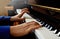 Child playing piano. Close up side view of young hands and fingers playing a song