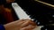 Child playing piano. Close up side view of young hands and fingers playing a song on the keys.