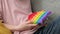 Child playing with pop it sensory toy cat form. Girl presses on colorful rainbow squishy soft silicone bubbles at home