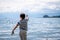 Child playing sands head down on the beach. One little Asian boy in casual clothing beside water in Switzerland