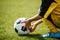 Child playing with soccer ball on grass venue. Little kid holding in both hands football ball