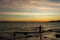 Child playing with sun is hiding the beach edge with