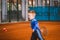 Child playing tennis on outdoor court. September 20, 2016. Ukraine, Kiev. Little tennis great player. Children sportswear adidas.