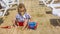 Child Playing With Toys In Sand