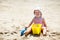 Child playing on tropical beach. Little girl digging sand at sea shore. Kids play with sand toys. Travel with young children