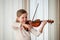 Child playing violin indoors