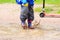 Child playing in water puddle, kids outdoor