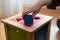 Child playing with wooden bricks in diffrent shapes and colors trying to put them into the proper hole