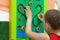 Child playing with wooden labirint in play center inside