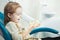 Child plays with artificial human jaw in dentist chair