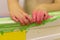 The child plays in the bathroom, draws with finger paints, the bathroom in the paint, green paint flows down the wall.baby hands