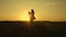 Child plays and fly in arms of mom at sunset in field. mother whirls with a small daughter in her arms, healthy child in