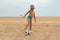 The child plays football on the beach