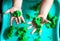 A child plays with kinetic sand. Hands of a child playing with green magic sand. Children`s creativity. Kinetic sand in a green