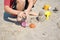 A child plays with molds in the sand. Beach holidays with children