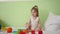 Child plays with multicolored cubes on a white bed and throws them to his mother. Educational toys for preschool and