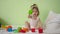 Child plays with multicolored cubes on a white bed and throws them to his mother. Educational toys for preschool and