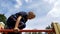 Child Plays in the Playground on the Uneven Bars against the Sky in Slow Motion