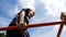 Child Plays in the Playground on the Uneven Bars against the Sky in Slow Motion