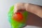 The child plays with a red and green slime, the baby crushes the slime with his hand