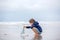 Child plays with sand on beach. Cute preschool boy with toy ship on beach. Stormy seaside sgore and kid playing