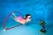 The child plays sports underwater. Dives and swims through the Hoop at the bottom of the pool.