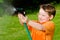 Child plays with water hose outdoors