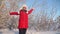 Child plays in winter in park for Christmas vacation. happy girl throws up snow with her hands at sunset in forest. Snow