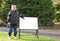 Child pointing to a blank sign in park