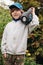 Child with portable speaker enjoying the music in park, outdoors. Kid listening music by wireless acoustic column at nature. Boy