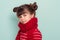 Child portrait of a 6 year old brunette, blue eyes, funny hairstyle wearing a red scarf and sweater, isolated