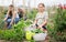 Child posing with baskets with vegetables in the garden