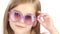 Child posing for video cameras with glasses. White background. Close up