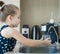 Child pouring fresh reverse osmosis purified water in kitchen at home. Drinking tap water. Consumption of tap water contributes to