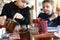 Child pouring tea in cafe