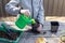 Child pours water from a watering can into a seedling pot with plant seeds