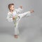 Child practicing karate in kick position