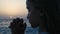 Child praying on beach at sunset, thoughtful prayer kid, pensive girl on seaside