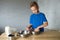 A child prepares dough in metal bowls. Trying the dough