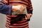 Child, preschooler, primary school student, puts money, banknotes, dollars, euros in a leather wallet, hands close-up